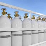 Ilustrasi Professional healthcare photography of clean, white medical oxygen cylinders being loaded carefully into a delivery van outside a medical clinic in Cikampek, daytime. Bright daylight, crisp focus on safety valves and metallic cylinders, high-end healthcare logistics aesthetic. Completely clean with absolutely no text, no branding logos, and no watermarks in the entire image.